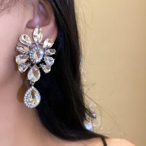 Detailed view of luxury floral rhinestone clip-on earrings with waterdrop pendant.