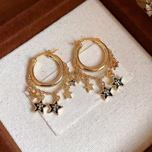 Goldene Creolen mit Sternenketten-Quasten und schwarzen Emaille-Details in einer Box