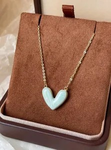 Detailaufnahme einer eleganten hellblauen Herz-Halskette mit Marmor-Effekt