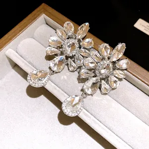 Detailed view of crystal floral teardrop drop earrings in a luxury jewelry display tray