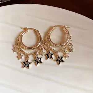 Elegante goldene Creolen mit schwarzen Emaille-Sternen und stilvollen Kettenquasten