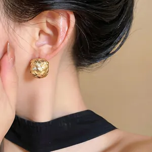 Detail of 18k gold plated woven C-shape ear clip shown on an Asian model ear