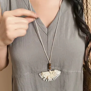 Detailed close-up of bohemian woven fan-shaped pendant necklace with wooden beads