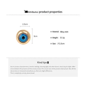 Detail eines goldenen Vintage-Alloy-Rings mit blauem Harz-Auge, Größe 3x2,5cm.