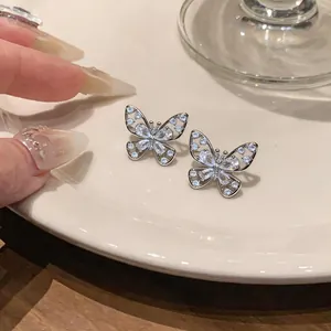 Macro view of sparkling silver butterfly hollow-out ear clips with zirconia stones