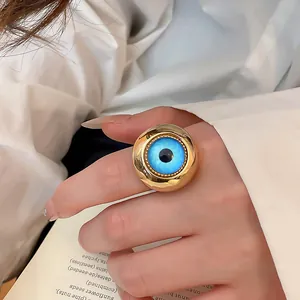 Detaillierte Makroansicht eines goldenen Vintage-Rings mit einem auffälligen blauen Auge