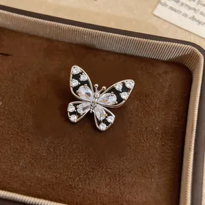 Detailed view of elegant gold butterfly clip-on earring with black enamel and crystals