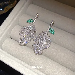 Elegant sparkling zircon leaf drop earrings displayed in a grey velvet jewelry gift box