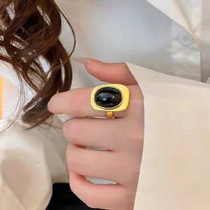 Detailansicht eines goldenen Vintage-Rings mit großem ovalen schwarzen Harzstein.