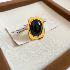 Detailansicht eines goldenen Vintage-Rings mit einem großen ovalen schwarzen Harz-Cabochon.