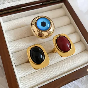 Nahaufnahme von Vintage-Harzringen in Rot, Schwarz und Blau in einer Schmuckschatulle