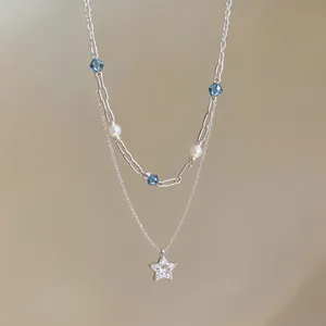 Detailed view of a double-layered necklace with a zircon star pendant and pearls