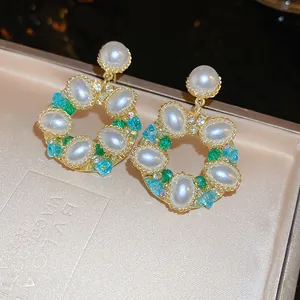Gros plan détaillé sur des boucles d'oreilles couronne vintage avec des perles.