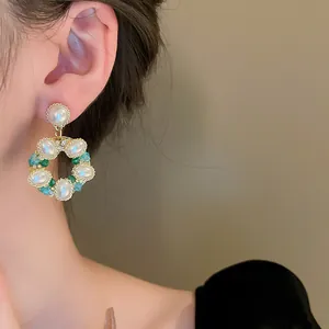 Gros plan sur des boucles d'oreilles couronne vintage avec perles et cristaux colorés