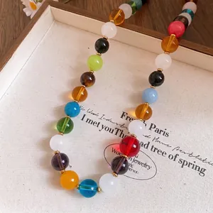 Vibrant multi-colored beaded necklace with gold spacers displayed on a jewelry tray.
