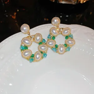 Vue macro de boucles d'oreilles couronne rétro avec perles et cristaux sur une assiette