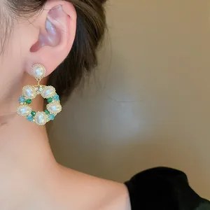 Zoom sur des boucles d'oreilles couronne vintage avec perles et cristaux colorés