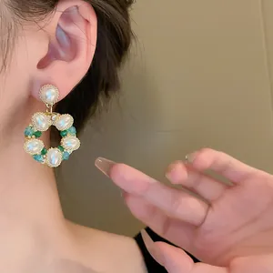 Vue détaillée de boucles d'oreilles vintage avec perles et cristaux sur l'oreille.