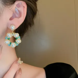 Détail de boucles d'oreilles couronne rétro française avec perles et cristaux verts