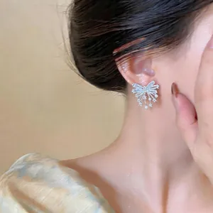 Elegant silver needle bow-knot earrings with shimmering cubic zirconia and pearl accents