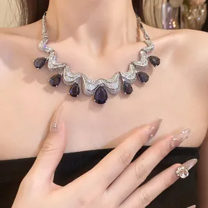 Close-up of an elegant teardrop zircon necklace featuring deep purple stones on a model