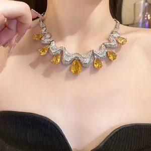 Close-up view of a luxury necklace featuring pear-shaped yellow zirconia stones on a model's neck