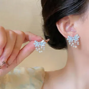 Macro detail of elegant butterfly zircon stud earrings with delicate pearl accents