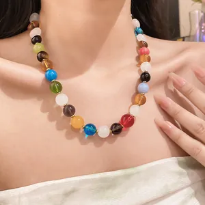 Detailed view of a colorful beaded necklace with translucent stones on a model's neck
