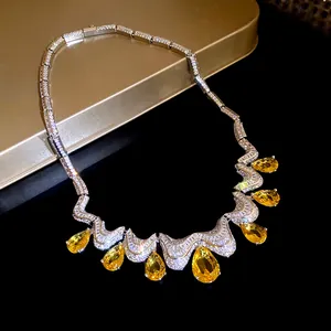 Detail of luxury necklace featuring yellow pear-shaped zirconia drops on sparkling chain.