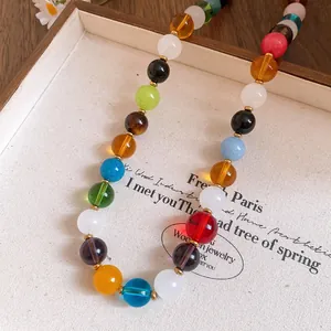 Close-up of vibrant multi-colored stone beads necklace with elegant gold spacers detail