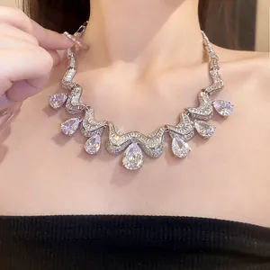 Macro detail of luxury silver teardrop zircon necklace shown on an elegant model neck