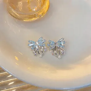 Close-up view of elegant light blue butterfly stud earrings with zircon and mini pearls