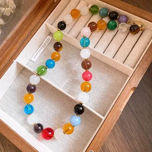 Close-up view of a vibrant colorful stone beaded necklace in a premium wooden jewelry box