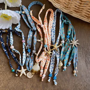 Collection of fabric printed necklaces with starfish and shell charms for beach style