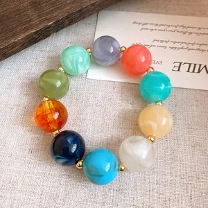 Detailaufnahme eines bunten Acrylperlen-Armbands auf einer dekorativen weißen Karte