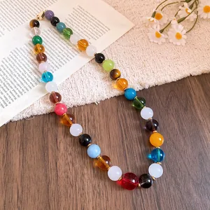 Detail view of a vibrant colorful stone beaded necklace with gold spacers