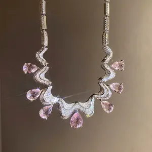 Sparkling necklace detail featuring pink pear-shaped stones and wavy zircon accents.