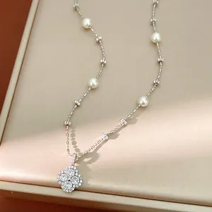 Close-up of elegant clover flower pearl necklace with sparkling CZ stones on beaded chain