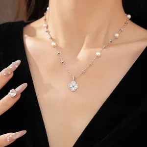 Detailed close-up view of an elegant clover pearl necklace with shimmering clear stones