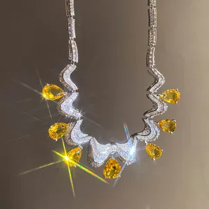 Close-up of a sparkling silver necklace featuring yellow pear-cut zirconia stones
