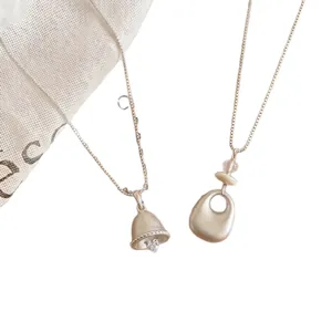 Silberne matte Glocke und abstrakte Anhängerketten im minimalistischen Stil für Damen