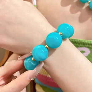 Lebhaftes türkisfarbenes Acrylperlenarmband mit marmorierter Textur und Goldakzenten