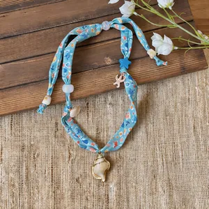 Close-up detail of the beach-themed fabric printed necklace with shell and starfish charms