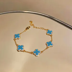 Detailansicht eines 18K vergoldeten Kleeblatt-Armbands mit türkisfarbenem Harzbesatz