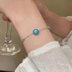 Detailansicht eines 18K vergoldeten Armbands mit Türkis-Harz und blauen Zirkonen.