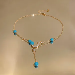 Detailansicht der 18K vergoldeten Halskette mit Mond Stern Anhängern und blauen Perlen