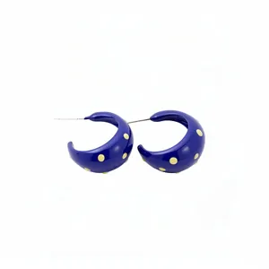 Fashionable C-shaped blue enamel hoop earrings with yellow polka dots and silver needles.