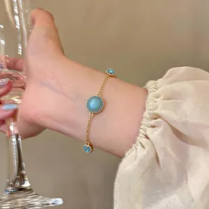 Detailansicht eines vergoldeten Armbands mit blauen Harzsteinen und Zirkonia