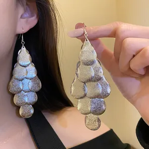 Close-up of matte silver metal drop tassel earrings showing retro layered design