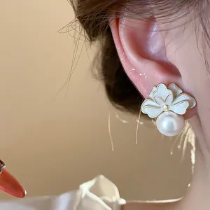 Close-up detail of exquisite French style flower pearl earrings worn on a female ear